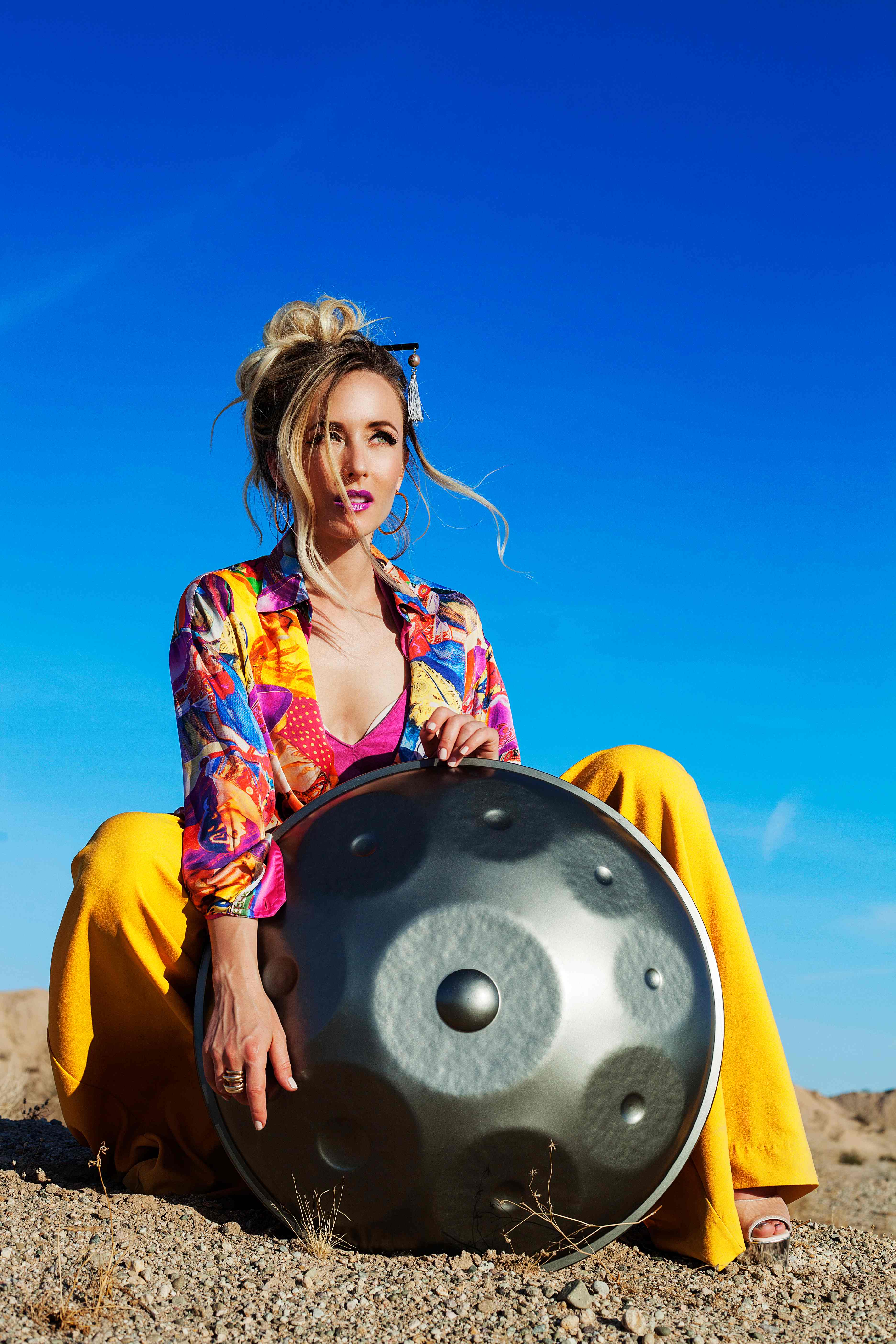 Sound healer with handpan drum in natural setting